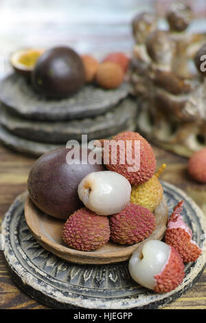 Les fruits tropicaux - Litchis et fruits de la passion ou Maracuya, sur fond de bois Banque D'Images