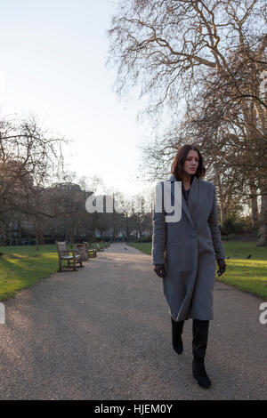 Belle dark haired woman marche seul dans un parc Banque D'Images