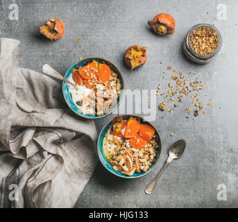 L'avoine, le quinoa muesli avec du yaourt, fruits secs, graines, miel, kaki Banque D'Images