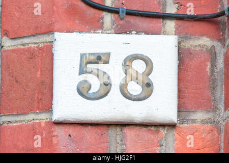 Numéro de maison 58 numéros en laiton - inscription sur un bloc en bois Banque D'Images