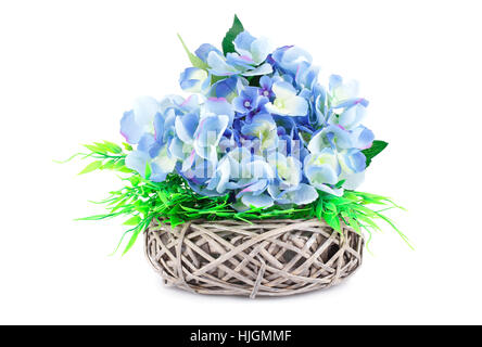Fleurs en tissu bleu dans l'osier vase isolé sur fond blanc. Banque D'Images