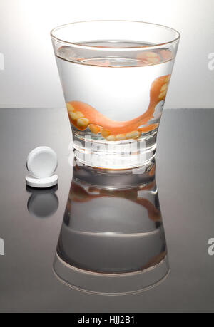 Le nettoyage d'un dentier dans un verre avec de l'eau.Bon d'hygiène. Banque D'Images