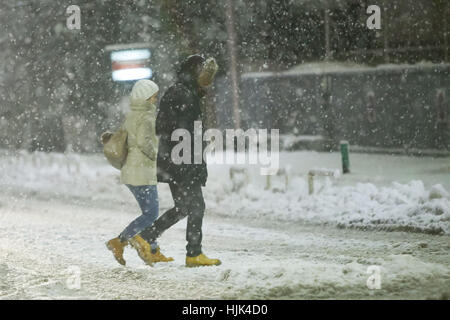 Zagreb, Croatie - Janvier 13th, 2017 : Un homme et une femme traversent la route au cours de fortes chutes de neige dans la région de Zagreb, Croatie. Banque D'Images