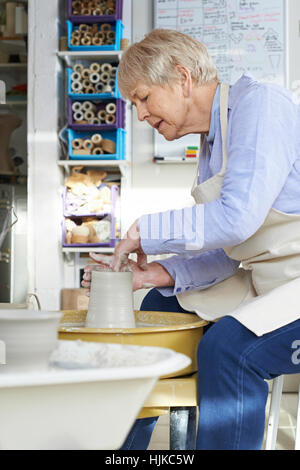 Hauts femme travaillant à roue en studio de poterie Banque D'Images