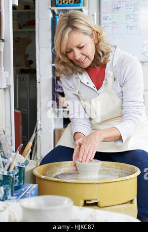 Young Woman Working at Potters Wheel In Studio Banque D'Images