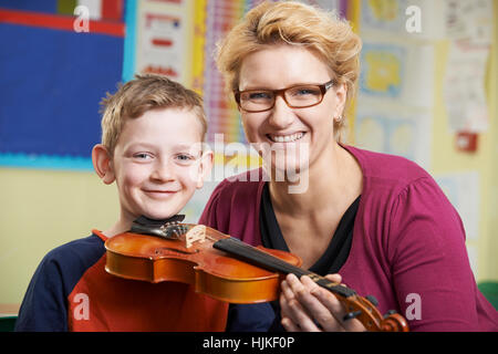 Aider l'enseignant élève mâle à jouer du violon dans la Leçon de Musique Banque D'Images