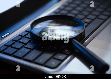 Selective focus sur le clavier avec loupe rechercher concept dans ton sombre nuit low key Banque D'Images
