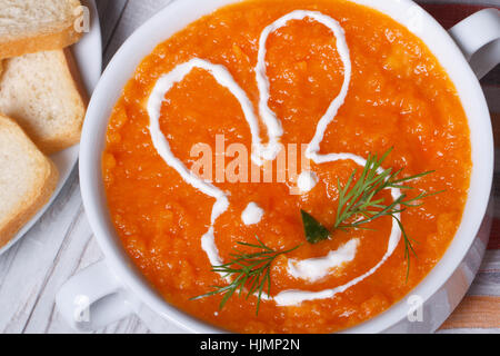 Soupe crème de carottes pour les enfants ayant des dimensions bunny close-up en plaque blanche horizontale. Vue de dessus. Banque D'Images