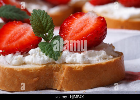 Sandwich avec fraises, fromage et menthe macro sur la table horizontale. Banque D'Images