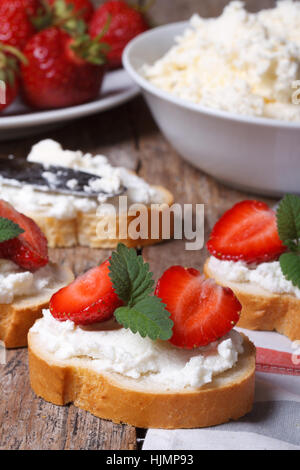 Cuisiner de délicieux sandwiches avec du fromage à pâte molle et de fraises fraîches. vertical. close-up Banque D'Images