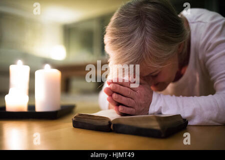 Hauts femme en prière, les mains jointes sur sa Bible. Banque D'Images