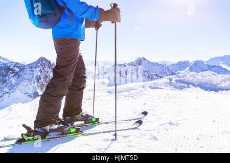 Close-up de bottes de ski et les skis sur la neige trail avec un beau blanc d'hiver ensoleillée paysage de montagnes en arrière-plan Banque D'Images