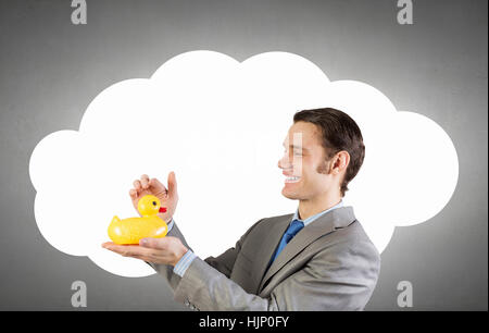 Funny businessman with yellow rubber duck toy Banque D'Images