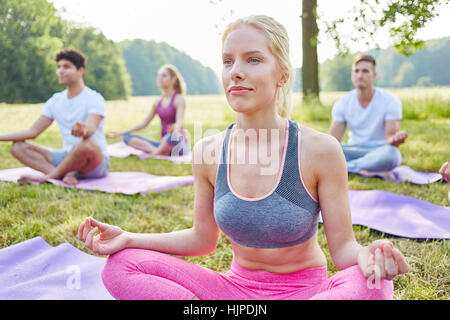 Jeune femme en faisant l'exercice de médiation atelier yoga pour sa santé Banque D'Images