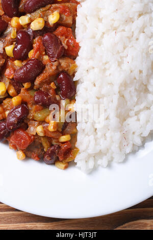 Chili con carne et riz sur une plaque blanche verticale macro vue du dessus Banque D'Images