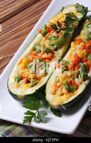 Courgettes farcies au fromage et légumes gros plan sur une plaque blanche Banque D'Images