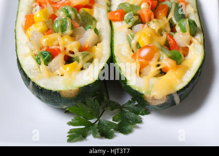 Cuit courgettes farcies au fromage et légumes gros plan sur une assiette blanche verticale Vue de dessus. Banque D'Images