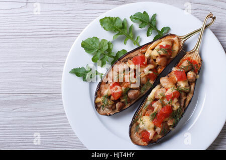 Aubergine farcie avec de la viande, du fromage et des tomates sur fond de bois close-up Vue de dessus de l'horizontale. Banque D'Images