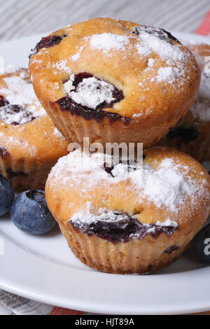 Cupcakes aux myrtilles sur plaque blanche libre sur une table de bois vertical. Banque D'Images