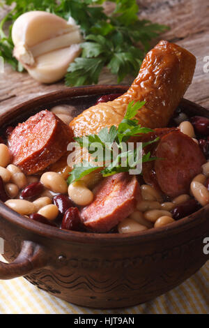 Soupe avec des haricots, des cuisses de poulet et les saucisses dans un bol sur la table. fermer jusqu'à la verticale Banque D'Images