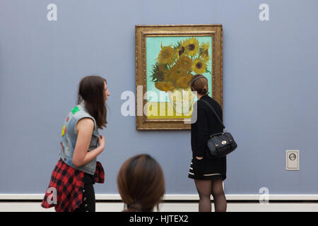 Visiteurs en face des peintures du tournesol (1888) par le peintre post-impressionniste Vincent van Gogh affiche dans la Neue Pinakothek (Nouveau Pinacotheca) à Munich, Bavière, Allemagne. Banque D'Images