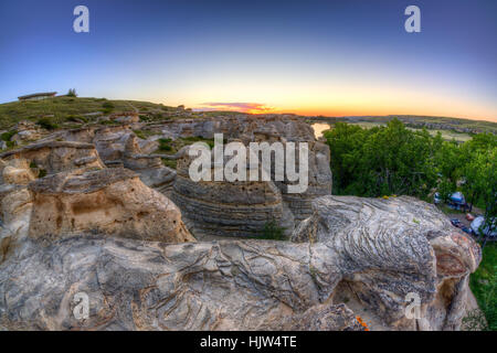 Lever du soleil sur l'or à l'écriture sur Hoodoo badlands Stone Provincial Park et Aisinaipi Site historique national en Alberta. Banque D'Images