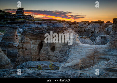 Lever du soleil sur l'or à l'écriture sur Hoodoo badlands Stone Provincial Park et Aisinaipi Site historique national en Alberta. Banque D'Images