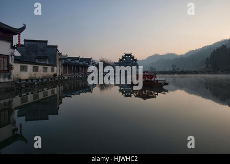 Brume sur le lac au lever du soleil dans l'ancien village de Xidi, Anhui, Chine Banque D'Images