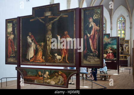 Visiteurs en face de l'Retable d'Issenheim (1512-1516) peintre allemand par Matthias Grunewald affiché dans le musée d'Unterlinden (Musée Unterlinden) à Colmar, Alsace, France. Première Vision de la Crucifixion du retable d'Issenheim avec encadré par les martyr de Saint Sébastien sur la gauche, et par Saint Antoine le Grand sur la droite. Banque D'Images