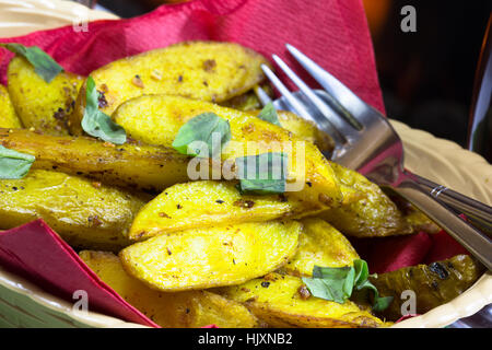 Végétarien/végétalien cuit épicé de Bombay les quartiers de pommes de terre servis dans un panier. Banque D'Images