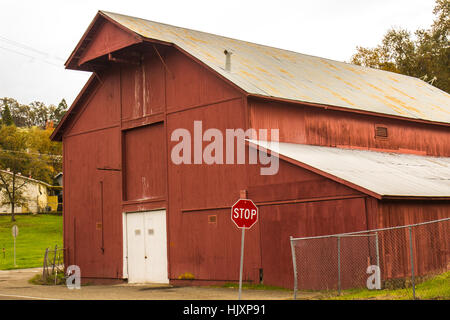 Vieille Grange rouge en ville avec toit en tôle Banque D'Images