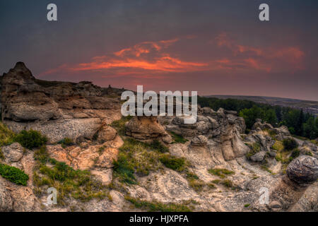 Lever du soleil sur l'or à l'écriture sur Hoodoo badlands Stone Provincial Park et Aisinaipi Site historique national en Alberta. Banque D'Images