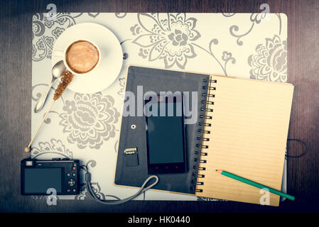 Le bloc-notes, tasse de café, smartphone et digatal capera sur le bureau. Concept de planification de voyage Banque D'Images