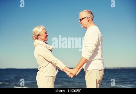 Happy senior couple holding hands summer beach Banque D'Images