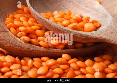 Les lentilles rouges secs dans un bol en bois horizontal macro. Banque D'Images