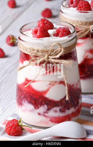 Yaourt framboise dans un bocal en verre gros plan sur table verticale Banque D'Images