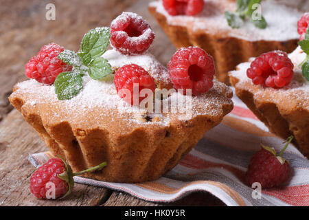 Muffins aux framboises avec du sucre en poudre, le gros plan horizontal table en bois Banque D'Images