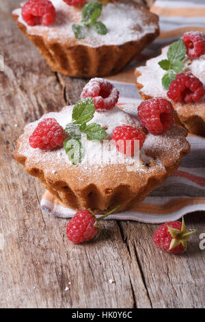 Muffins aux framboises avec du sucre en poudre, gros plan sur vertical table en bois Banque D'Images