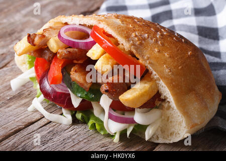 Döner Kebab avec de la viande, des légumes et des frites dans le pain pita close-up sur une serviette l'horizontale Banque D'Images