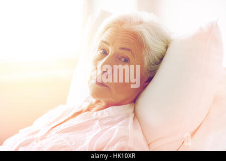 Femme senior patient lying in bed at Hospital ward Banque D'Images