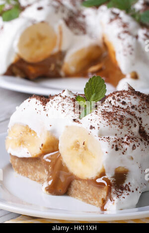 Morceau de gâteau avec de la crème de banane et menthe close up sur la table. vertical Banque D'Images