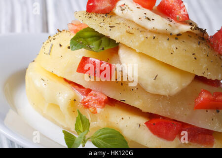 Bouillir les pommes de terre farcies à la mozzarella, tomates et basilic close-up l'horizontale Banque D'Images