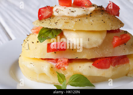 Tranches de pommes de terre farcies à la mozzarella, tomates et basilic close-up l'horizontale Banque D'Images