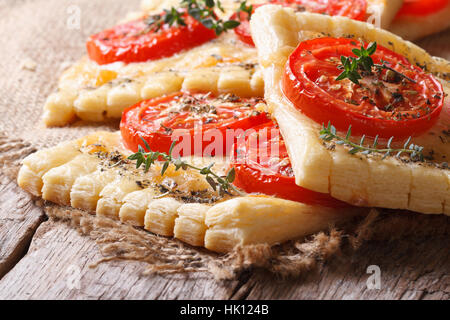 Pâte feuilletée traditionnelle avec tomates, fromage et herbes libre sur la table horizontale. Banque D'Images