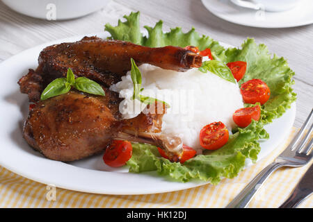 Cuisse de canard rôti avec du riz et de la salade sur le gros plan de la plaque à l'horizontale. Banque D'Images