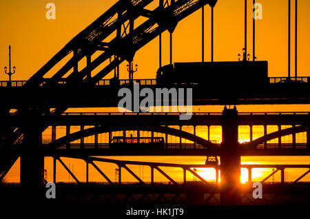 Newcastle Upon Tyne, Angleterre, Royaume-Uni. Vue vers le bas du fleuve Tyne du quai alors que le soleil se couche derrière le célèbre Pont Tyne, le High Level Bridge et le métro Pont. Banque D'Images