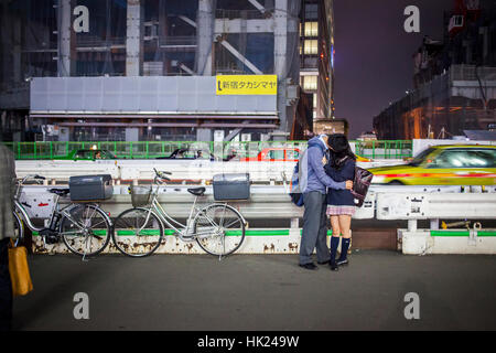 Couple kissing, dans Koshukaido Avenue, en face de la gare JR Shinjuku, Shinjuku, Tokyo Banque D'Images