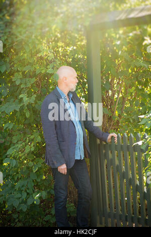 Vieil homme en attente porte de jardin. Moment de vie d'une personne âgée. Banque D'Images