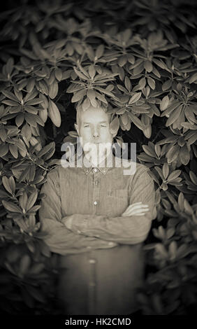 Portrait de vieil homme entouré de feuilles de bush. Concept de la vieillesse et de la nature. La retraite et la confiance. Banque D'Images