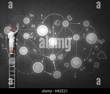 Vue arrière de femme debout sur l'échelle et l'élaboration des concepts de vie sur le mur Banque D'Images